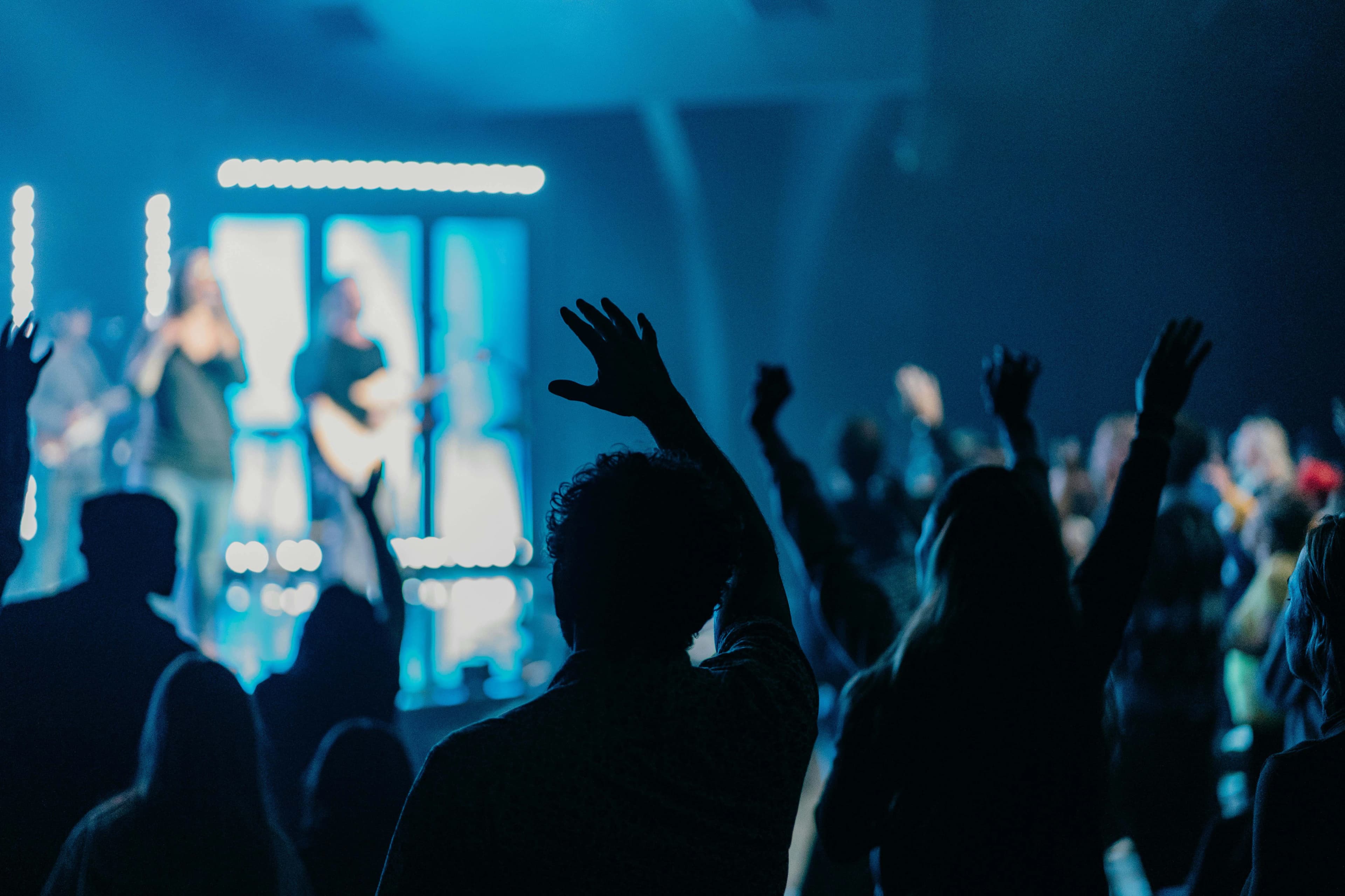 worship service at a church in Liverpool with people raising hands in praise